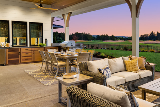 Outdoor kitchen wood cabinets in outdoor living space with BBQ and fridge beside sitting area, custom deck lighting, and other accessories.
